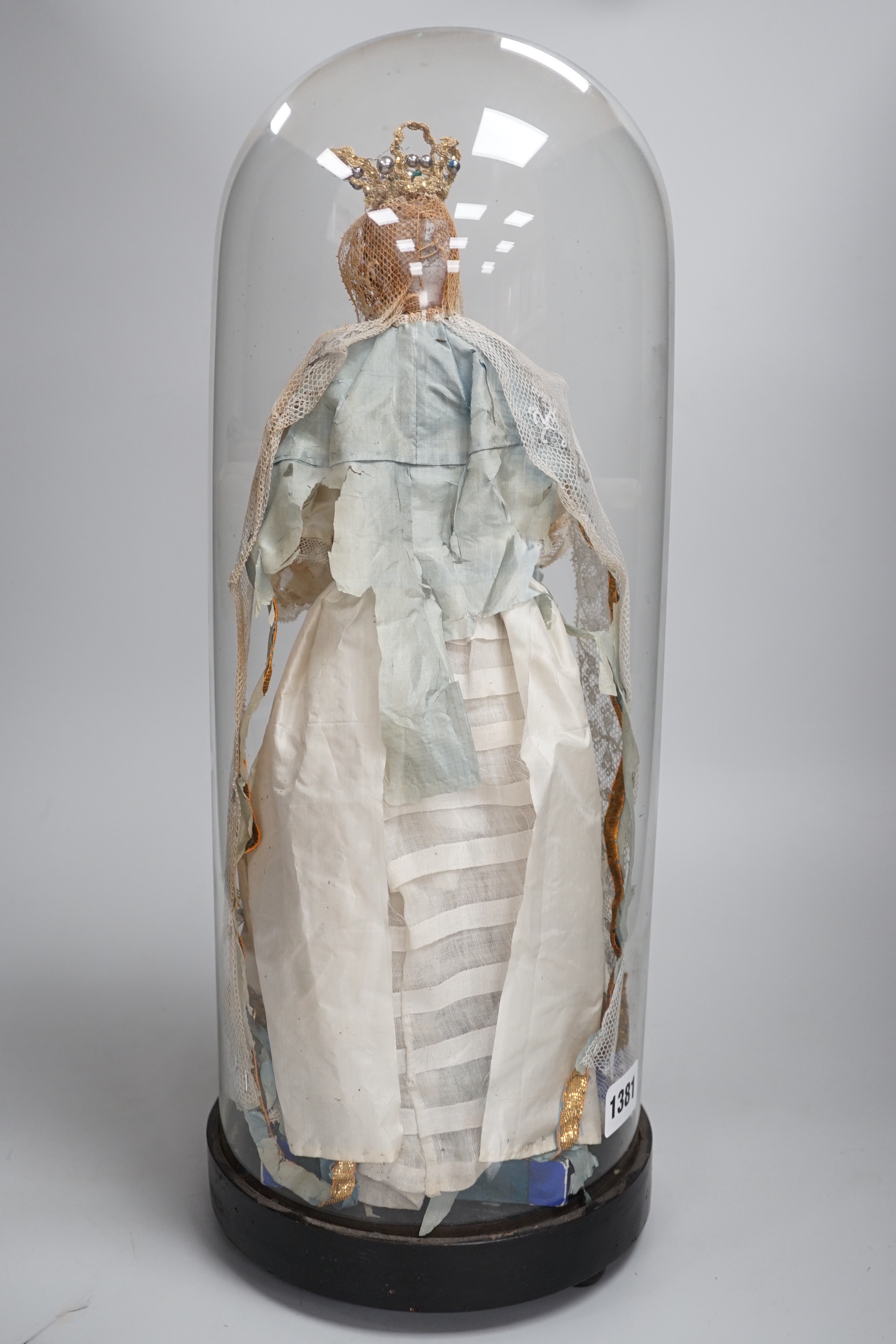 A waxed dressed figure with crown holding a baby under a glass dome 49.5cm high